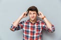 Confused unhappy young man in headphones listening to music Royalty Free Stock Photo