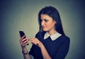 Confused upset woman looking at her mobile phone Royalty Free Stock Photo