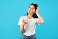 Confused upset young woman holding mobile phone