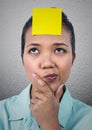 Confused woman with blank sticky note on her forehead Royalty Free Stock Photo