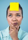 Confused woman with blank sticky note on her forehead Royalty Free Stock Photo