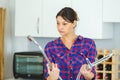 confused woman comparing two kitchen taps Royalty Free Stock Photo