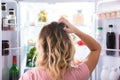 Confused Woman Looking In Open Refrigerator Royalty Free Stock Photo