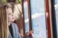 Confused woman looking to timetables in train station