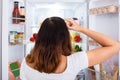 Confused Woman Searching For Food In The Fridge Royalty Free Stock Photo