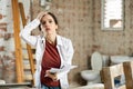 Confused woman standing with papers in apartment during renovations