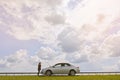 A confused woman waits for help near a broken car with the hood open, stands on the side of the road, calling for help, Calls and Royalty Free Stock Photo