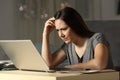 Confused woman working online late hours Royalty Free Stock Photo