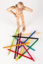 Confused wood mannequin standing at pencils