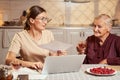 Confused worker with document turning for advice to elderly person