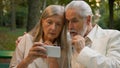 Confused worried Caucasian old senior couple retired family elderly man woman looking smartphone receiving bad news Royalty Free Stock Photo