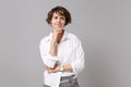 Confused young business woman in white shirt posing isolated on grey wall background in studio. Achievement career Royalty Free Stock Photo