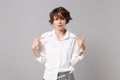 Confused young business woman in white shirt posing isolated on grey wall background studio portrait. Achievement career Royalty Free Stock Photo