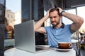 Angry bearded man with laptop in street cafe Royalty Free Stock Photo