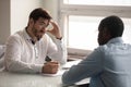 Confused young hr manager listening to african american job applicant. Royalty Free Stock Photo