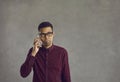 Confused young black man holding mobile phone, making call and waiting for answer Royalty Free Stock Photo