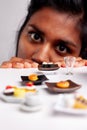 Confused young woman eyeing healthy versus unhealthy food Royalty Free Stock Photo