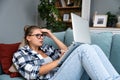 Confused young woman looking on laptop at home feeling bewildered by no connection, reading online news in internet, annoyed teen Royalty Free Stock Photo