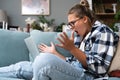 Confused young woman looking on laptop at home feeling bewildered by no connection, reading online news in internet, annoyed teen