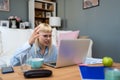 Confused young woman looking on laptop at home feeling bewildered by no connection, reading online news in internet, annoyed teen