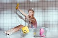 confused young woman in wash tub holding retro telephone Royalty Free Stock Photo
