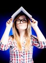 Confused young girl holding exercise book on her h Royalty Free Stock Photo