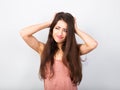 Confusion grimacing brunette woman thinking and looking up in pink t-shirt. portrait on blue background Royalty Free Stock Photo