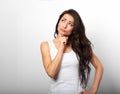 Confusion grimacing brunette woman thinking and looking up in white t-shirt on white copy space background Royalty Free Stock Photo