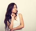 Confusion grimacing brunette woman thinking and looking up in white t-shirt. Toned vintage portrait Royalty Free Stock Photo