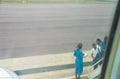 Congolese stewardess checks passenger entering airplane.