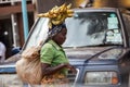 Congolese  woman in traditional African clothing  carries bananas on her head Royalty Free Stock Photo
