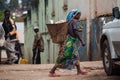 Congolese  woman in traditional African clothing  carries heavy basket on her head Royalty Free Stock Photo