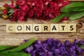 Congrats alphabet letter with Blooming flower on wooden background