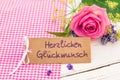 Congratulation card with german text, Herzlichen Glueckwunsch, means congratulation and pink rose flower