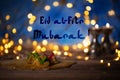 Congratulation: Eid al-Fitr Mubarak! Arabic sweets on a wooden s