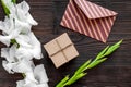 Congratulation. Envelope and box in kraft paper near flower gladiolus on wooden table top view