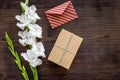 Congratulation. Envelope and box in kraft paper near flower gladiolus on wooden table top view copyspace