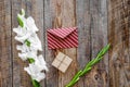 Congratulation. Envelope and box in kraft paper near flower gladiolus on wooden table top view copyspace