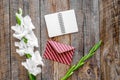 Congratulation. Envelope, notebook and box in kraft paper near flower gladiolus on wooden table top view