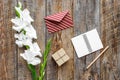 Congratulation. Envelope, notebook and box in kraft paper near flower gladiolus on wooden table top view