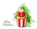 Congratulations on Christmas. Santa Claus on a cupcake on the background of a Christmas tree