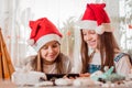 Congratulations in quarantine. Girls in Christmas decorations laugh and communicate with their families through a tablet Royalty Free Stock Photo