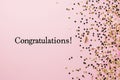 Congratulations text on pastel pink background with gold confetti Royalty Free Stock Photo
