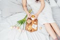 Congratulations to your beloved woman on Valentine`s Day. Breakfast in bed for a girl in a nightgown. Flowers and a gift for Royalty Free Stock Photo