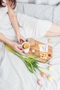 Congratulations to your beloved woman on Valentine's Day. Breakfast in bed for a girl in a nightgown. Flowers and a gift for Royalty Free Stock Photo