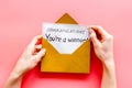 Congratulations You`re a winner. Hands holding envelope with letter. Pink background top view Royalty Free Stock Photo