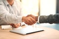 Congratulations, youre hired. two unidentifiable business partners shaking hands over a table in the office. Royalty Free Stock Photo