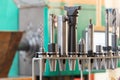 Conical and collet mandrels with cutters and drills on the rack, accessories for the milling machine