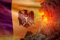 Conical volcano blast eruption at night with explosion on Moldova flag background, problems of natural disaster and volcanic ash