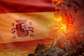 conical volcano blast eruption at night with explosion on Spain flag background, problems of disaster and volcanic earthquake